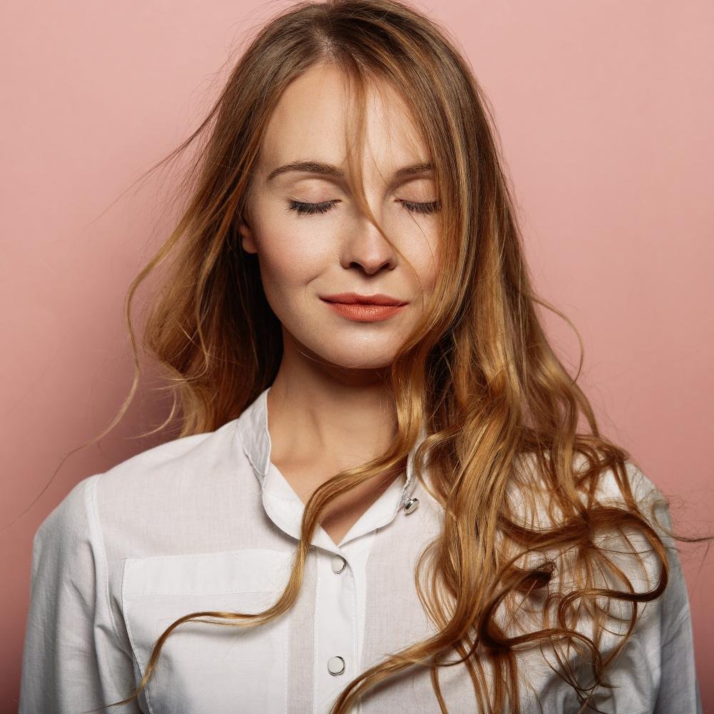 Femme aux cheveux longs et brillants après un soin capillaire naturel
